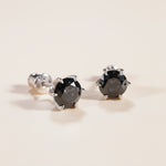 Pair of black moissanite earrings showing secure prong setting and backs.