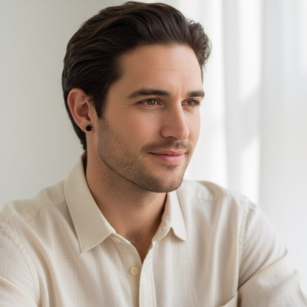 Man wearing black moissanite stud earrings, platinum silver setting.