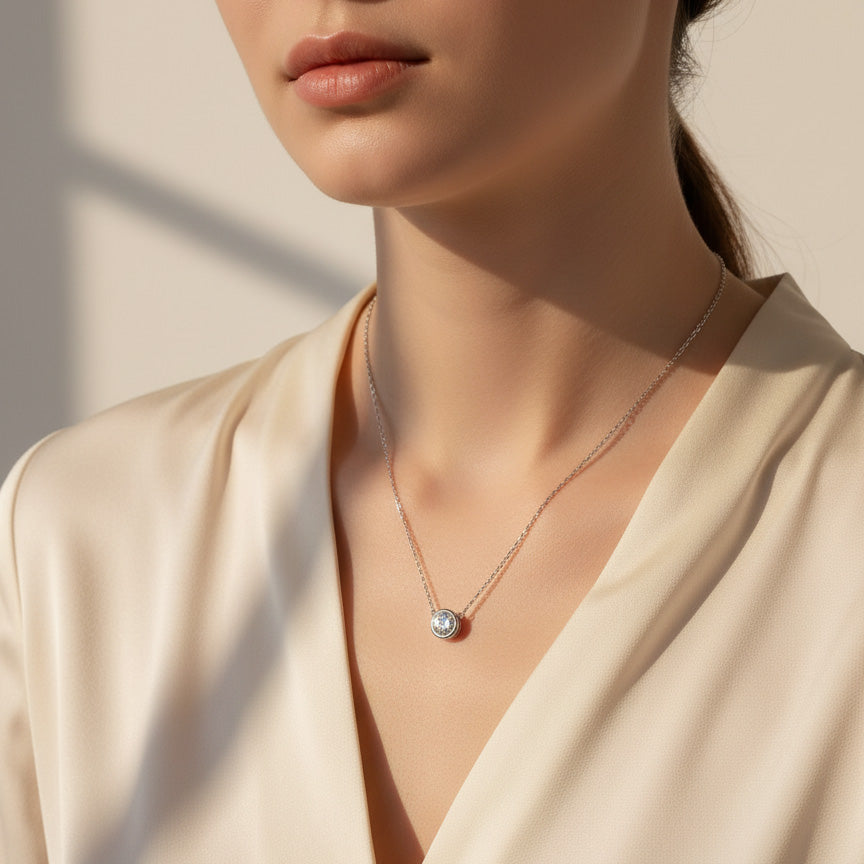 Woman wearing bezel moissanite lab grown diamond necklace, minimalist style.
