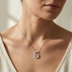 Personalized letter necklace with a letter 'S' pendant worn by a person