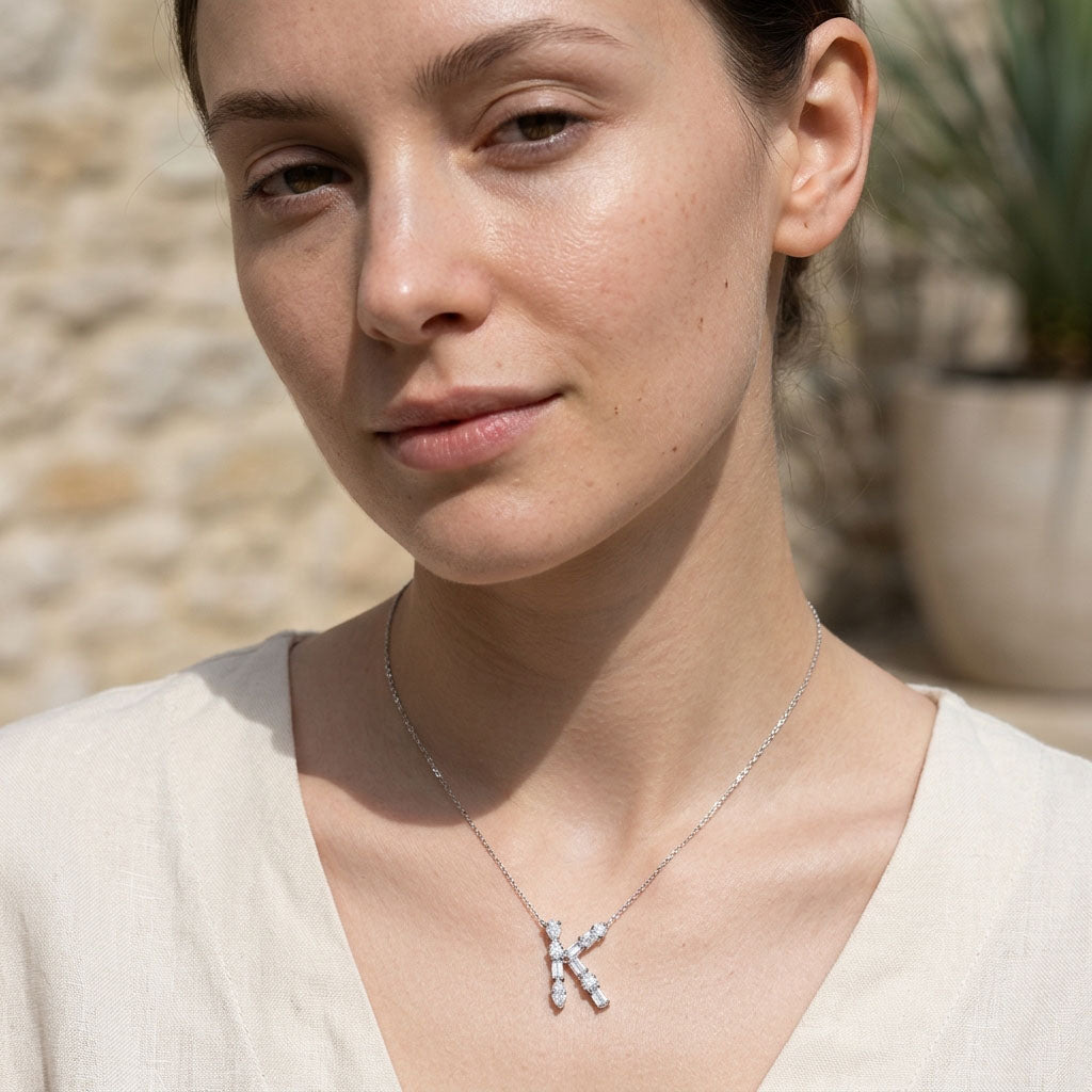 Woman wearing moissanite necklace with a 'K' pendant outdoors
