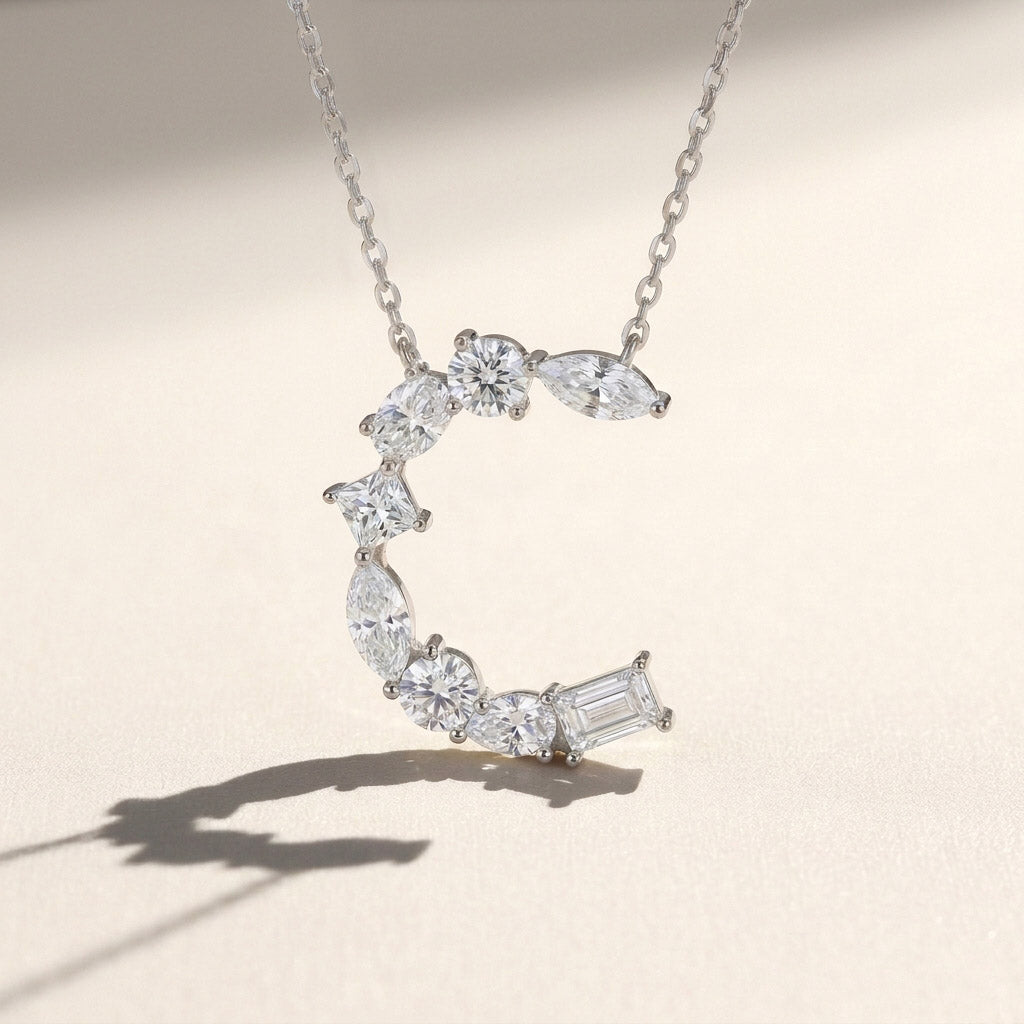 Diamond necklace with a letter 'C' pendant on a light background