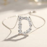 Diamond necklace with a letter 'D' pendant on a light background