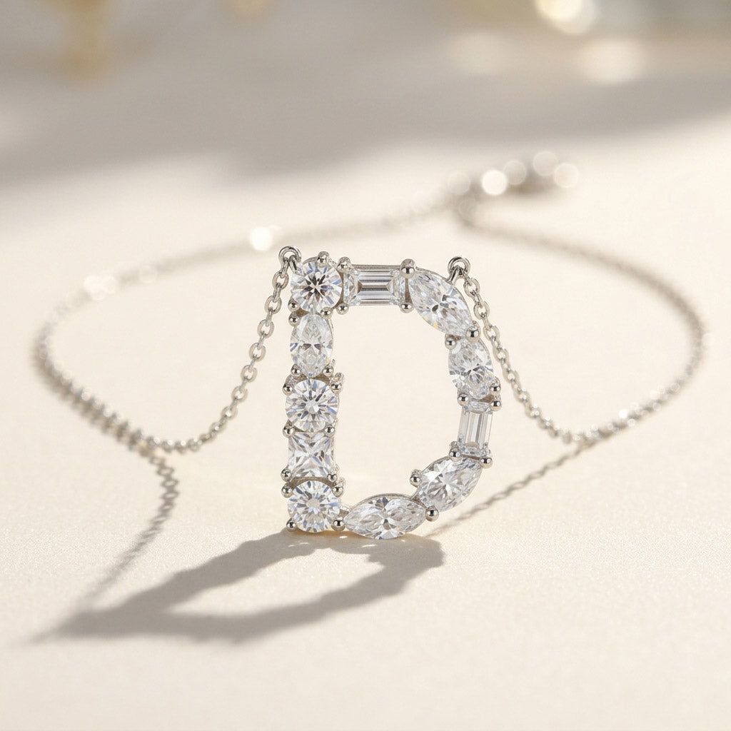 Diamond necklace with a letter 'D' pendant on a light background
