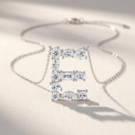 Diamond necklace with 'E' pendant on a light background