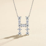Diamond necklace with 'H' design on a beige background