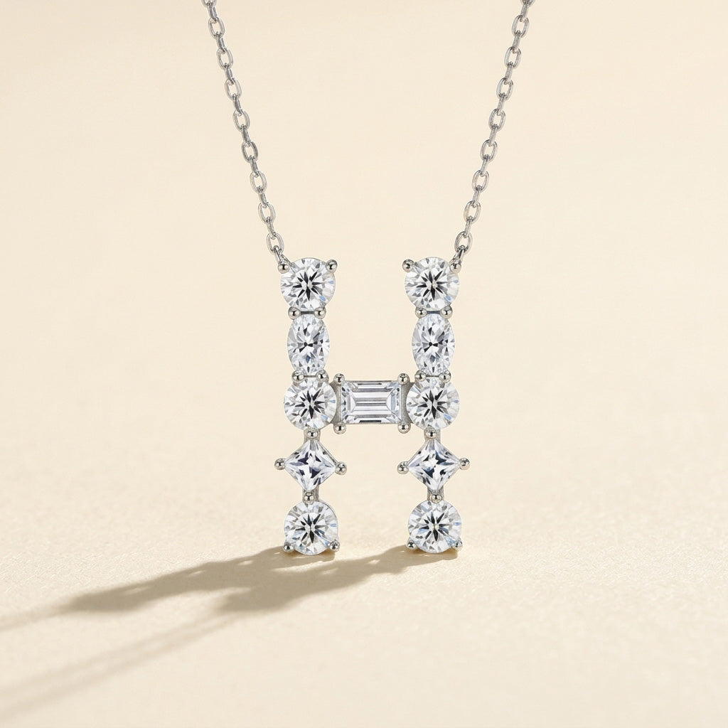 Diamond necklace with 'H' design on a beige background