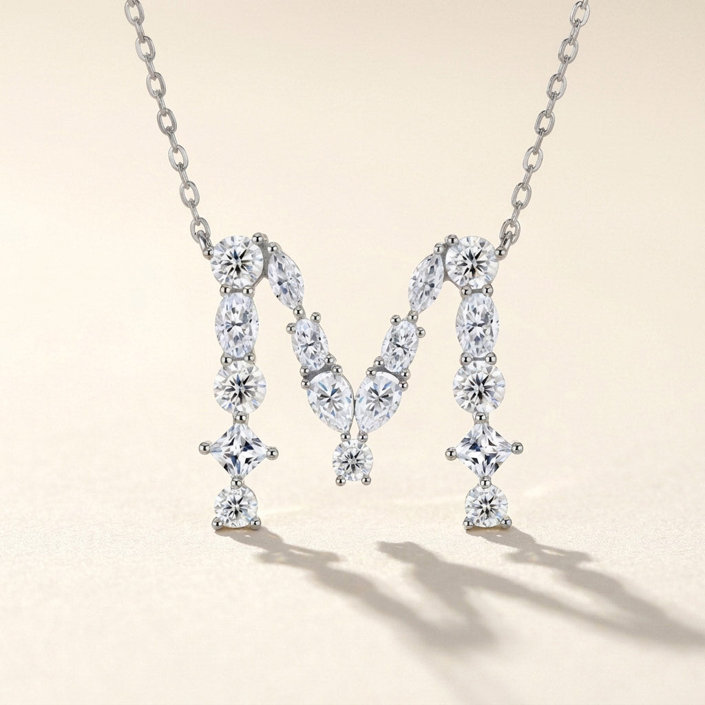 Diamond necklace with a 'M' design on a beige background