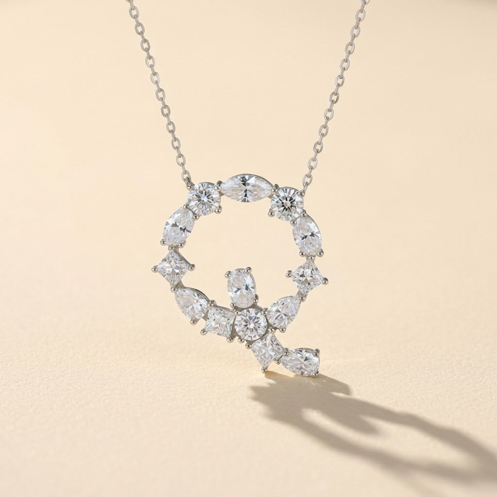 Diamond necklace with a letter 'Q' pendant on a light background