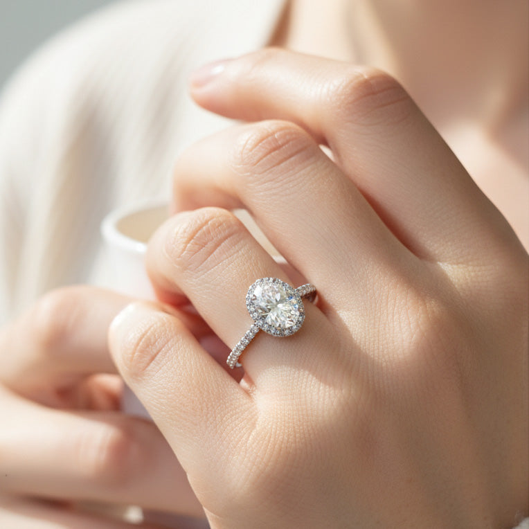 Model wearing oval-cut lab-grown diamond halo engagement ring in sterling silver