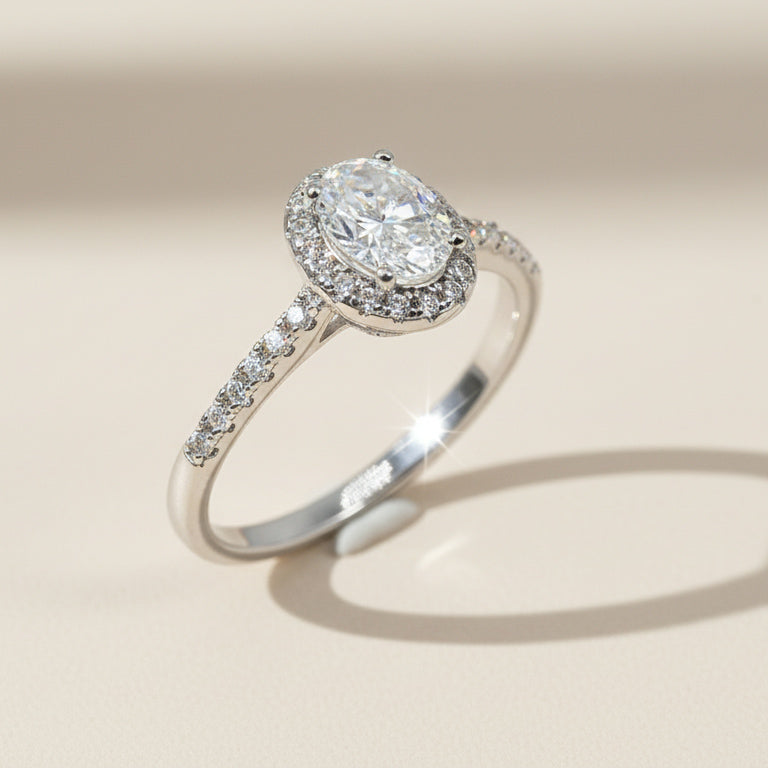 Oval lab-grown diamond halo ring in sterling silver with pavé band under natural light