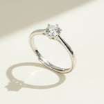 Angled close-up of classic six-prong round diamond solitaire ring in sterling silver