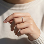 Minimalist diamond eternity band in sterling silver worn on hand, showcasing delicate sparkle