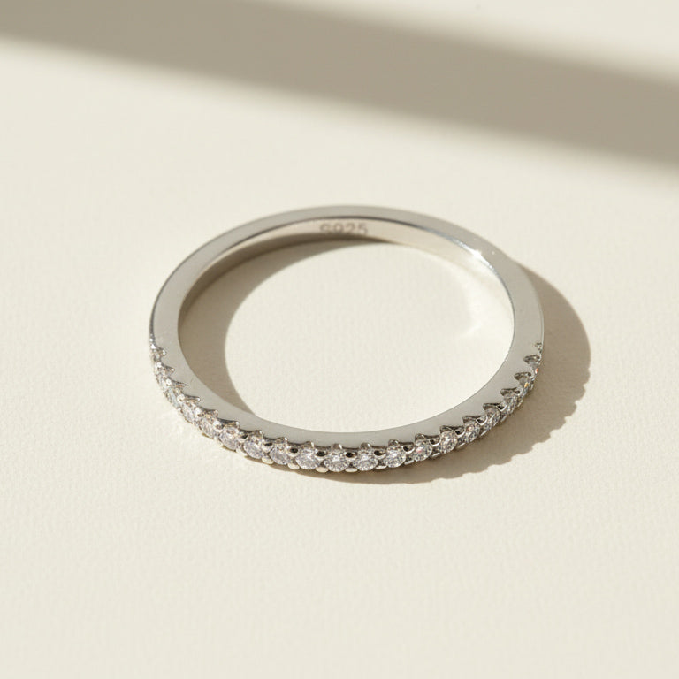 Close-up of sterling silver eternity ring with pavé-set round diamonds marked S925 inside band