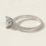 Side view of round-cut lab-grown diamond solitaire ring with pavé band in sterling silver