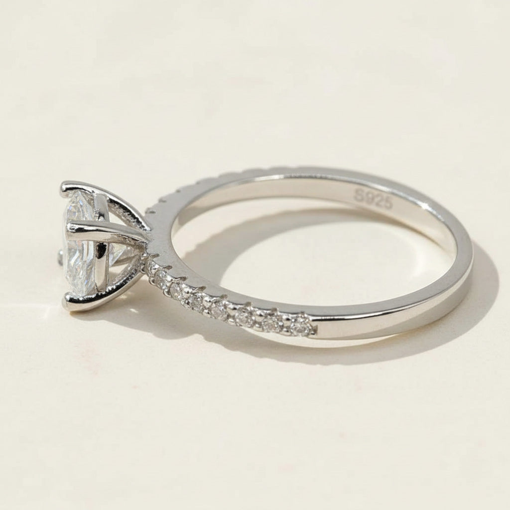 Side view of round-cut lab-grown diamond solitaire ring with pavé band in sterling silver