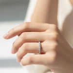 Model wearing sterling silver eternity band with seven lab-grown diamonds in claw settings