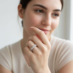 Woman wearing seven-stone silver diamond eternity band by window in soft natural light