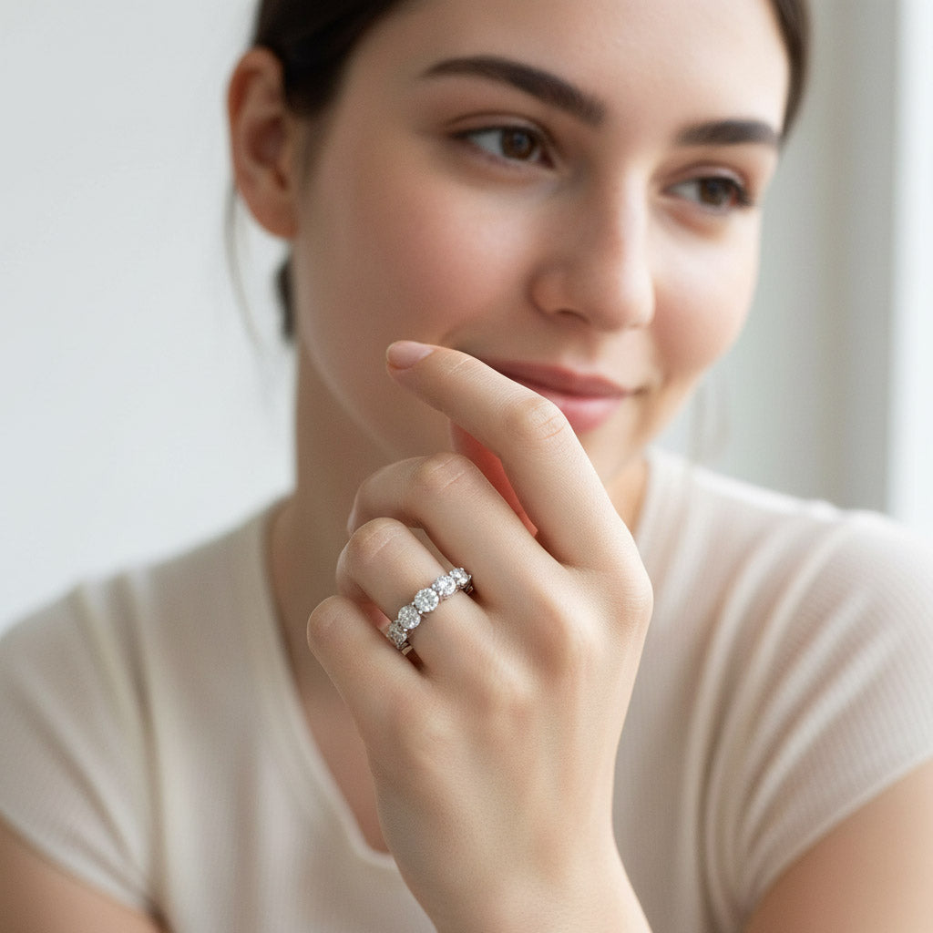 Woman wearing seven-stone silver diamond eternity band by window in soft natural light