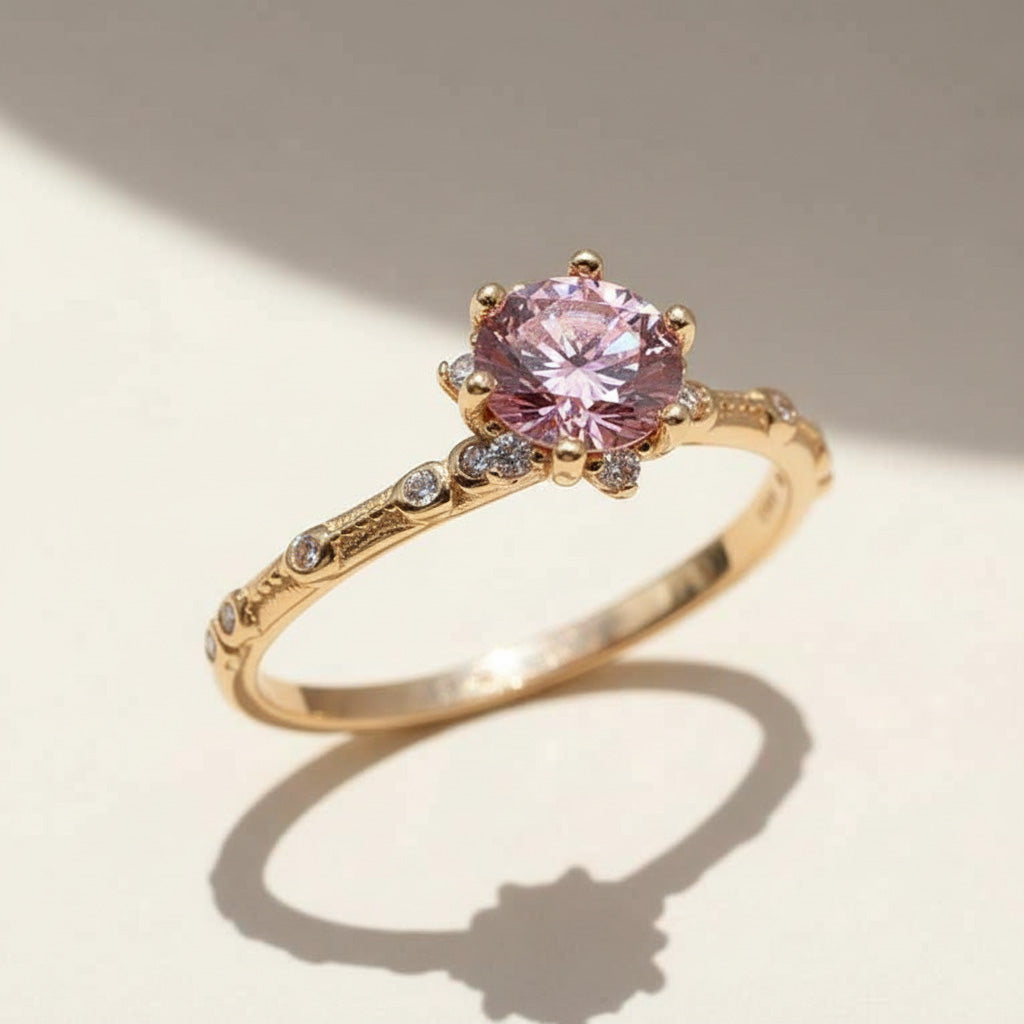 Vintage-inspired rose gold pink moissanite engagement ring with intricate diamond-accented band