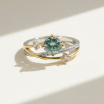 Platinum and gold-plated moissanite ring with green gemstone and accent diamonds