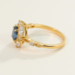Side view of gold sapphire halo ring with intricate band detailing and accent stones