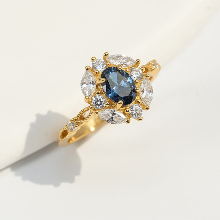 Gold vintage halo ring featuring oval sapphire and marquise-cut lab-grown diamonds