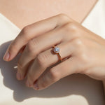 Rose gold halo diamond ring on hand, round lab-grown diamond with pavé sparkle band