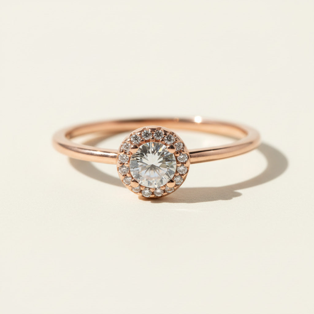 Rose gold halo engagement ring with round lab-grown diamond center and pavé accent stones.