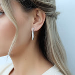 Model wearing sterling silver lab-grown diamond hoop earrings, medium size sparkle design