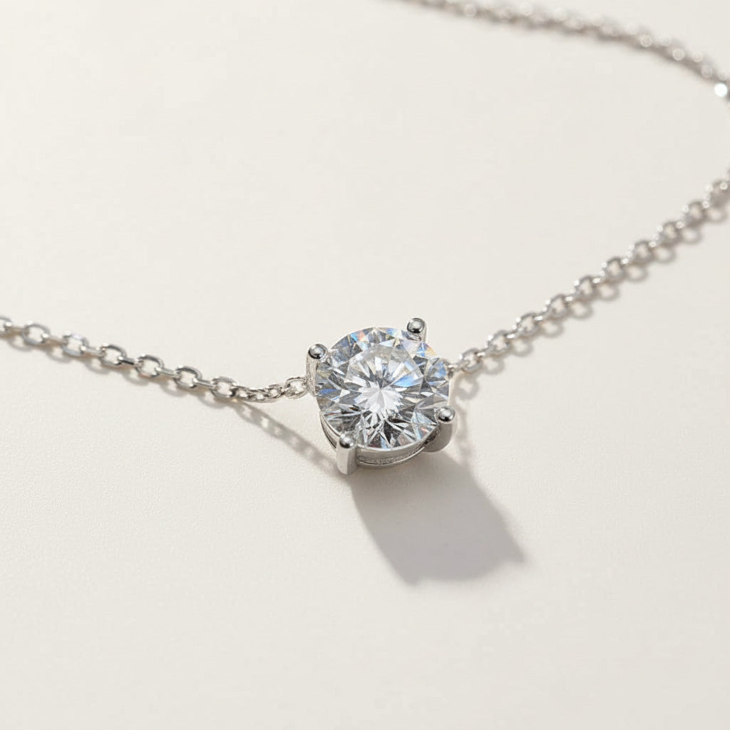 Sterling silver solitaire necklace with round lab-grown diamond pendant, classic minimalist design.