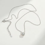 Platinum-plated sterling silver necklace featuring a round lab-grown moissanite solitaire pendant with 925 tag.