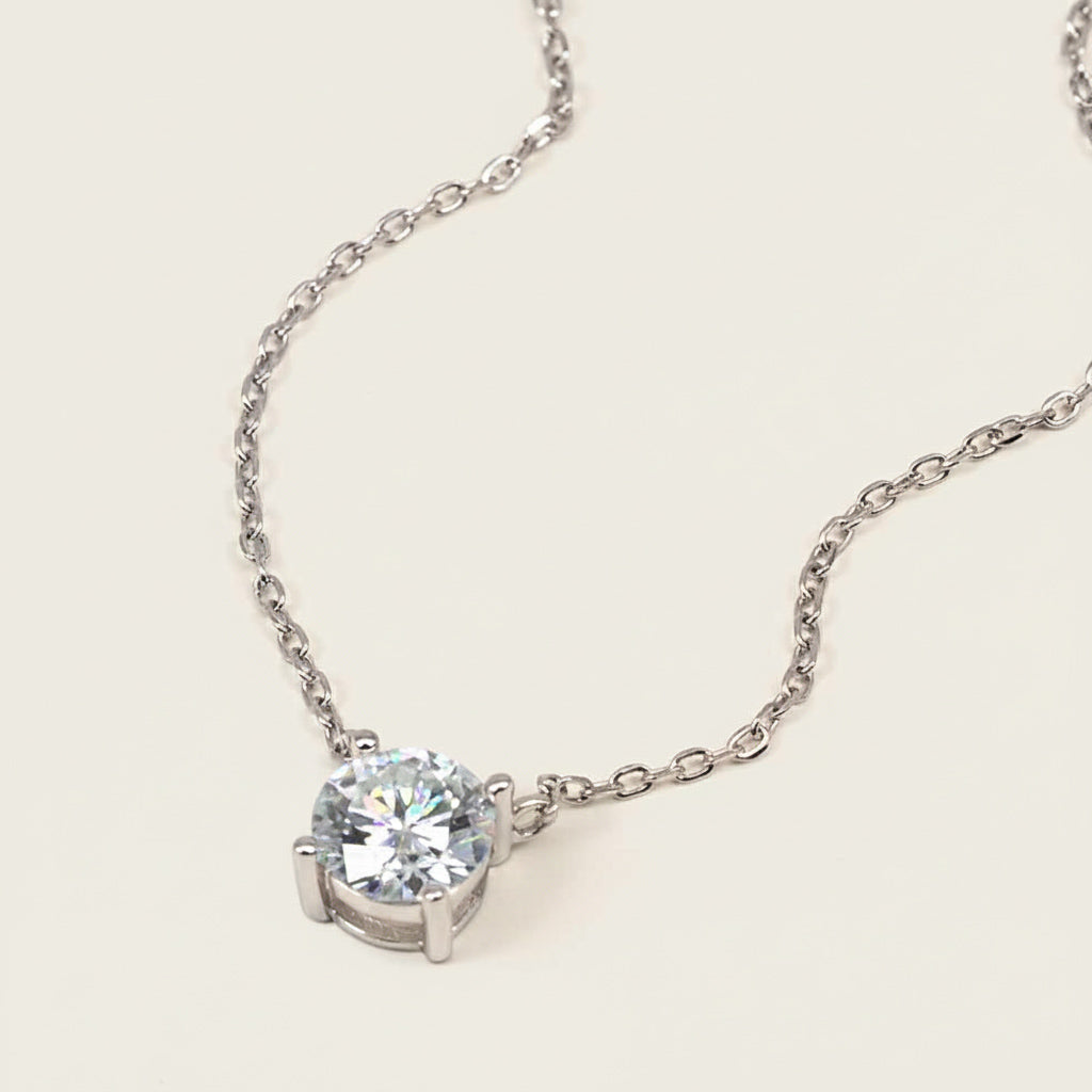 Platinum-plated sterling silver necklace with a round lab-grown moissanite solitaire pendant in a claw setting.