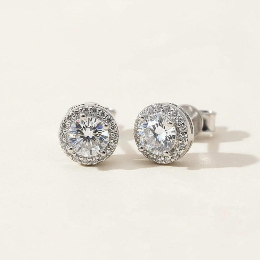 Platinum-plated sterling silver stud earrings with 0.5ct lab-grown moissanite center stones and halo design.