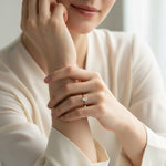 Pear cut moissanite solitaire ring on model’s hand in gold plating