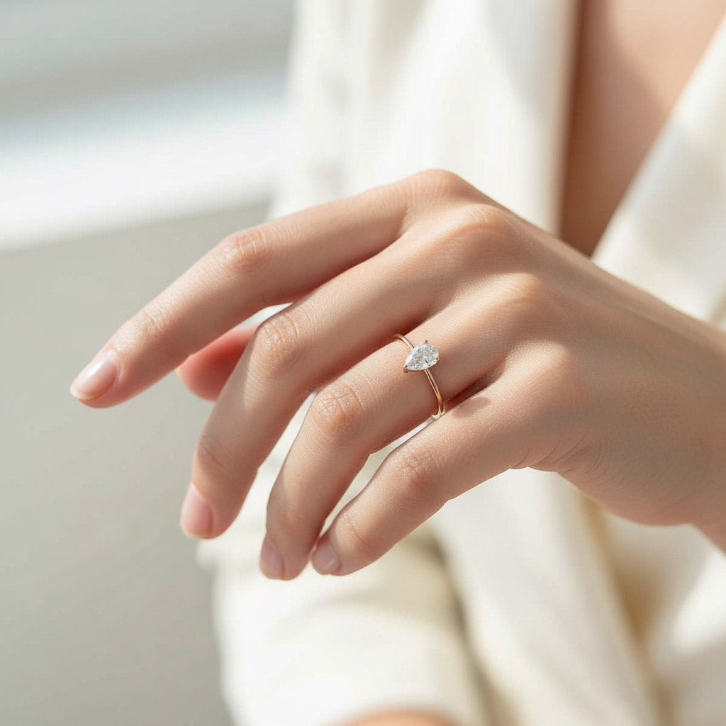 Model wearing rose gold pear cut moissanite ring