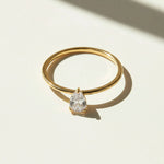 Gold pear cut moissanite ring photographed under sunlight