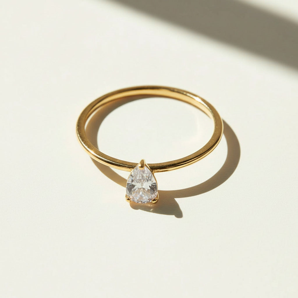 Gold pear cut moissanite ring photographed under sunlight