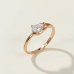 Rose gold-plated sterling silver ring with pear-cut lab grown moissanite solitaire, elegant minimalist design.