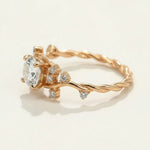 Gold-plated vine-style ring with round moissanite center stone and CZ accents on a twisted band by A2K London.
