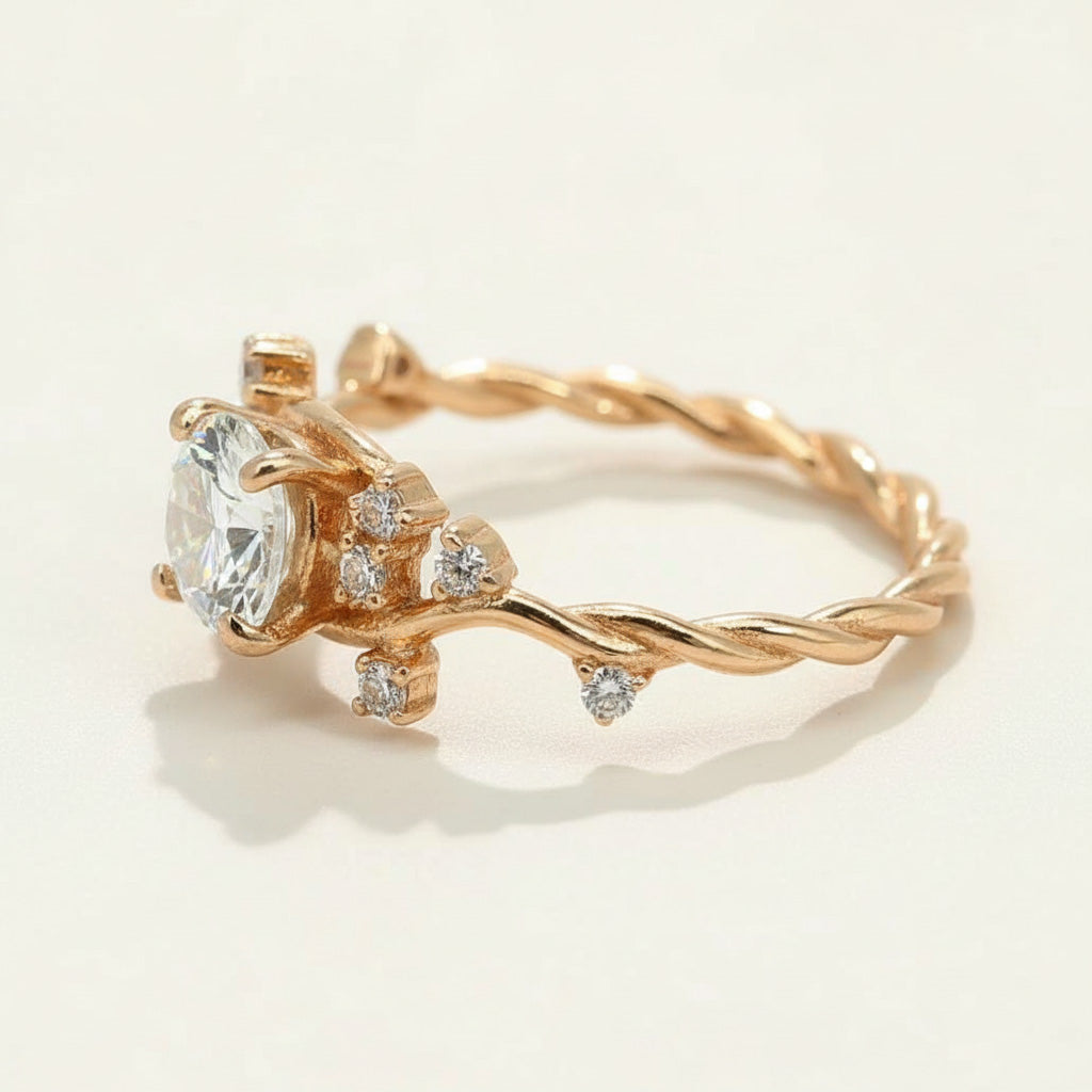 Gold-plated vine-style ring with round moissanite center stone and CZ accents on a twisted band by A2K London.