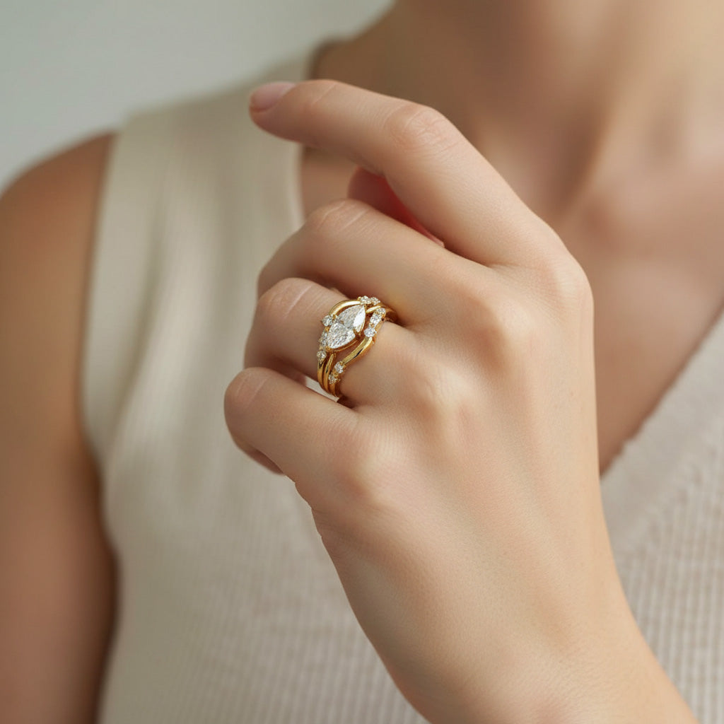 Gold-plated sterling silver moissanite ring set with marquise-cut center stone shown on hand by A2K London.