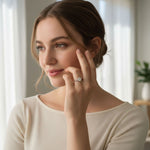 Model showcasing oval three-stone D/VVS1 moissanite ring in silver.