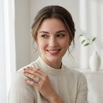 Woman wearing a diamond ring, smiling indoors with a neutral background
