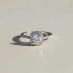1ct moissanite halo ring in platinum plated sterling silver on neutral background