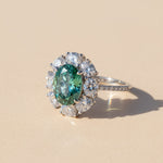 Close-up of oval halo moissanite ring in platinum plated sterling silver setting