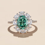 Oval halo ring with topaz blue center stone in platinum plated sterling silver, moissanite accents