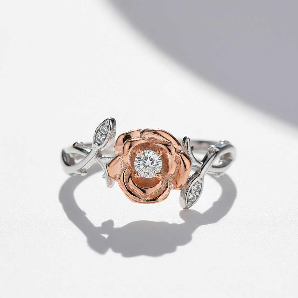 Close-up of 0.1ct D/VVS1 moissanite rose ring with platinum silver leaves on a light gray background