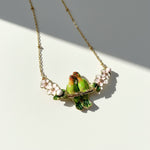 Necklace with a green bird and flower pendant on a white background