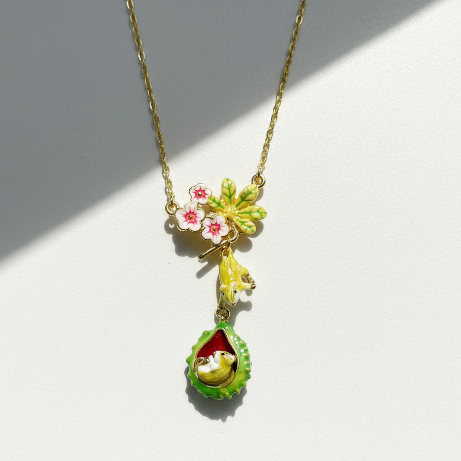 Necklace with a floral and mouse pendant on a white background